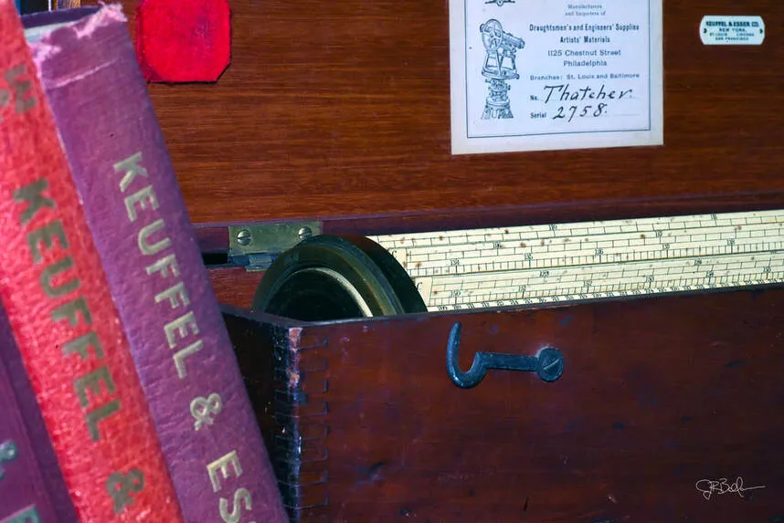 A decorative close-up photograph of the Thacher Calculator's box, case, and drum