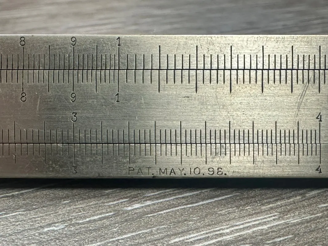Close-up of the hand-etched Pat. May. 10. 98 patent mark on the Model 4095 Triangular Metal Rule