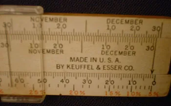 The K&E TimeSlide Calendar Slide Rule, showing November/December date scales and a percentage scale
