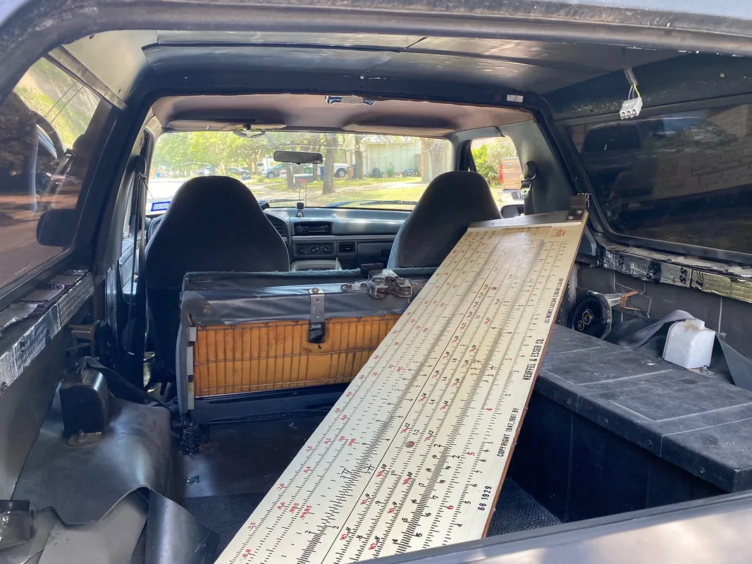 A 6.5 foot K&E Deci-Lon demonstration slide rule laid diagonally across a truck bed