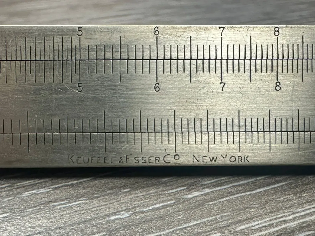 Close-up of the hand-etched Keuffel & Esser Co., New York maker's mark on the Model 4095 Triangular Metal Rule