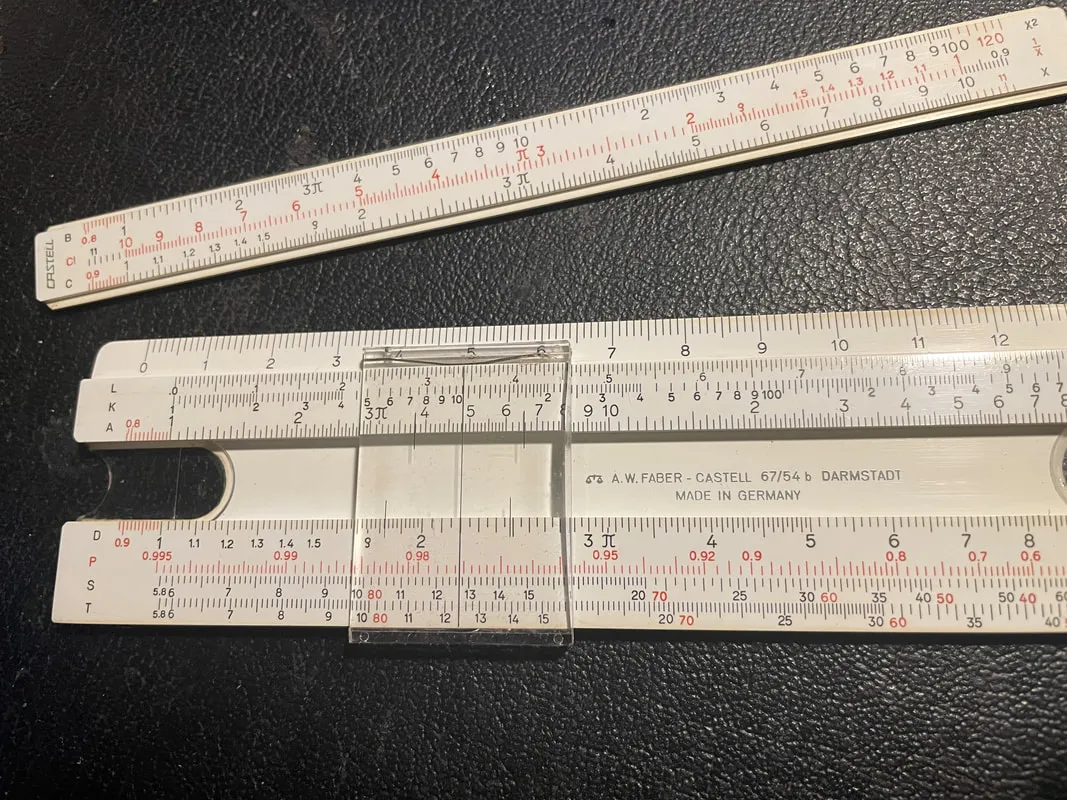 A slide rule with the slide removed, set to find the outputs of 2.2